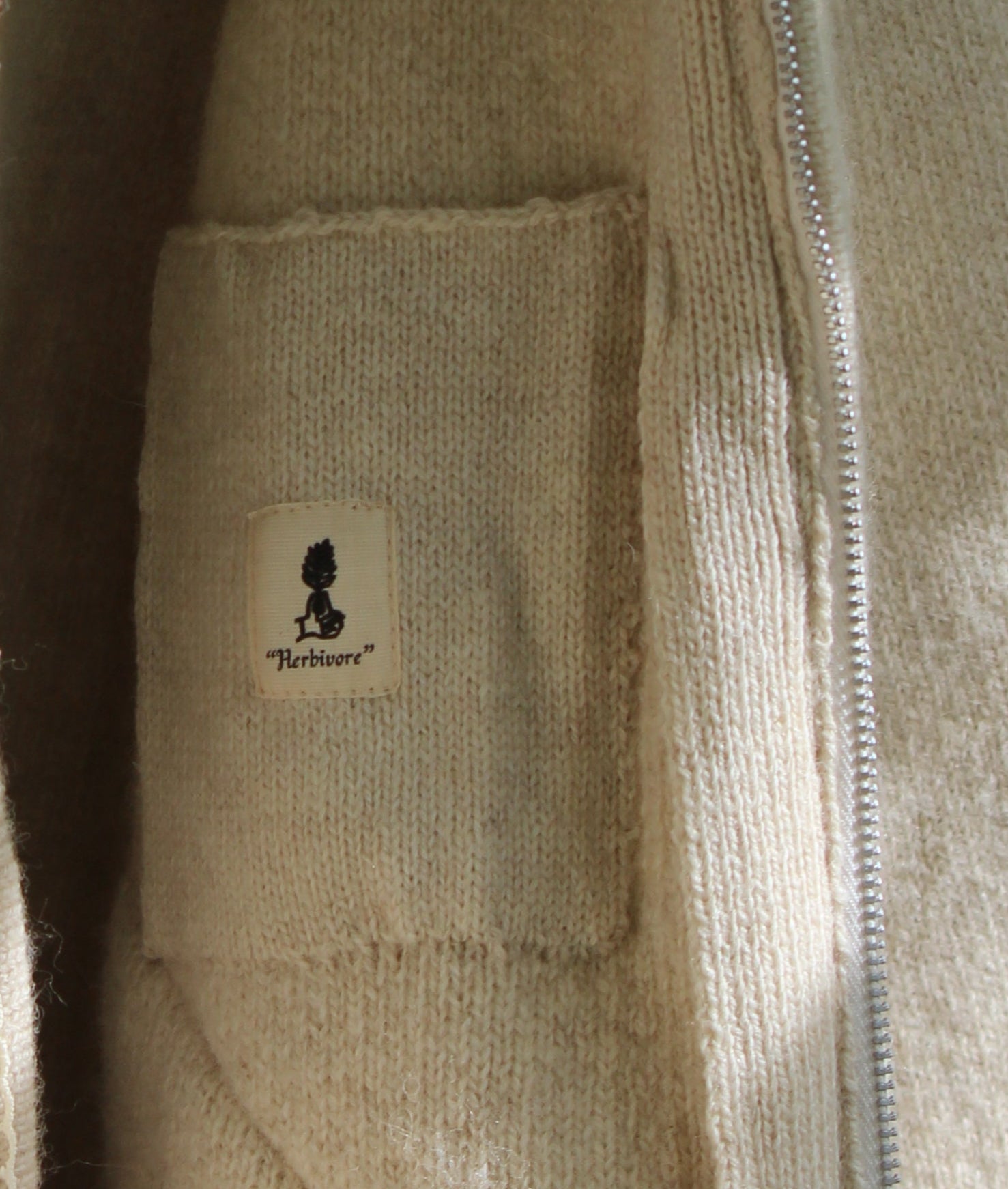 Unisex beige wool jacket detailed image of fastening and pockets, close distance