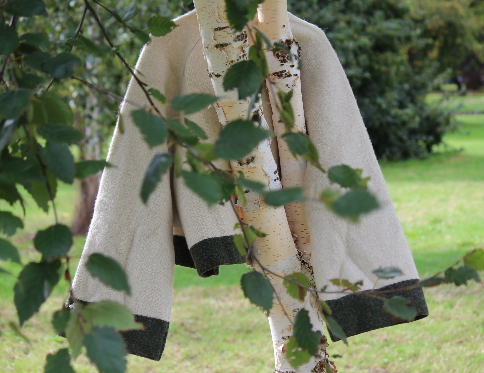 Unisex beige wool jacket cinematic product shot in a tree, middle distance