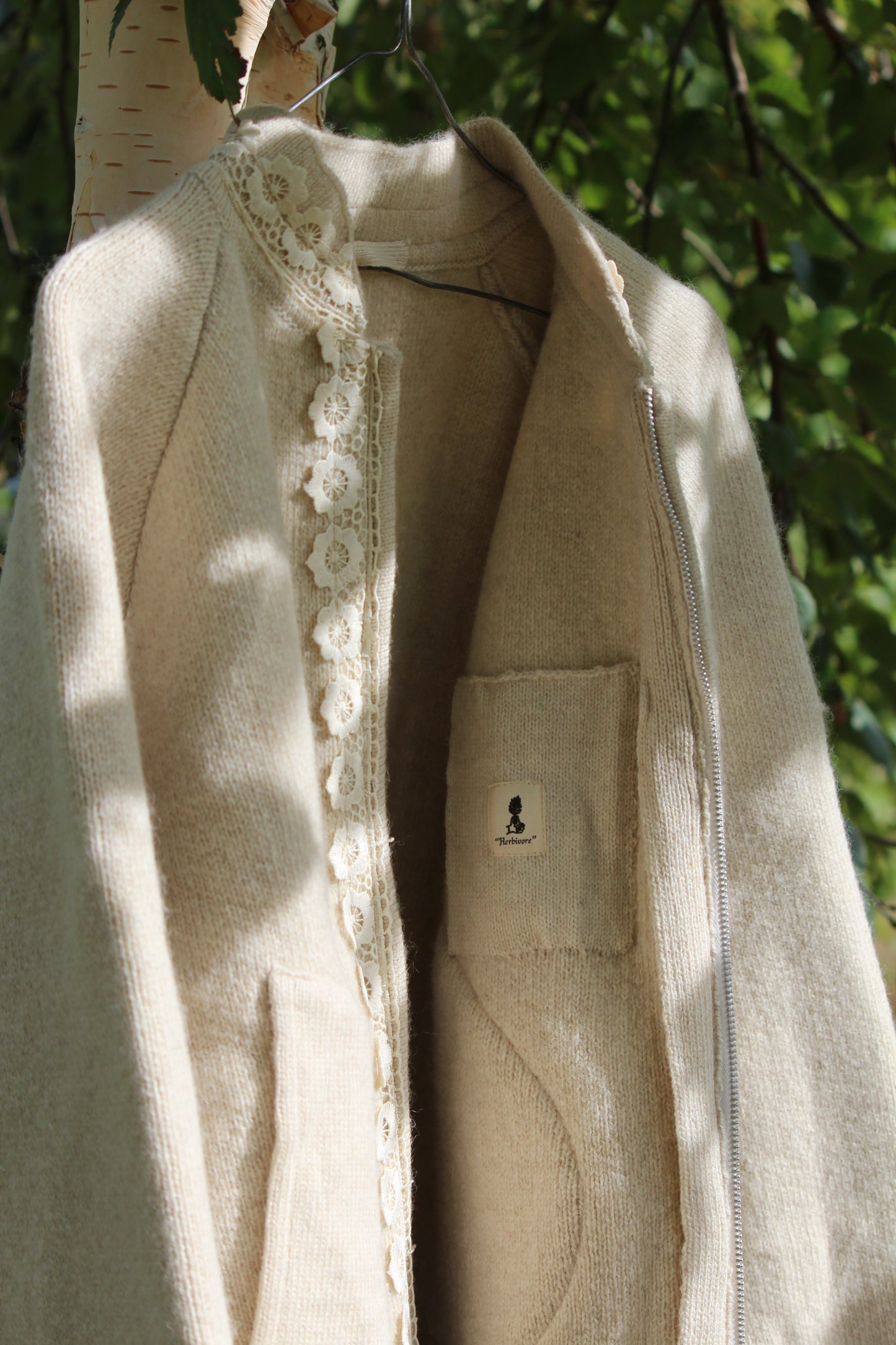 Unisex beige wool jacket detailed image of fastening and pockets, close distance